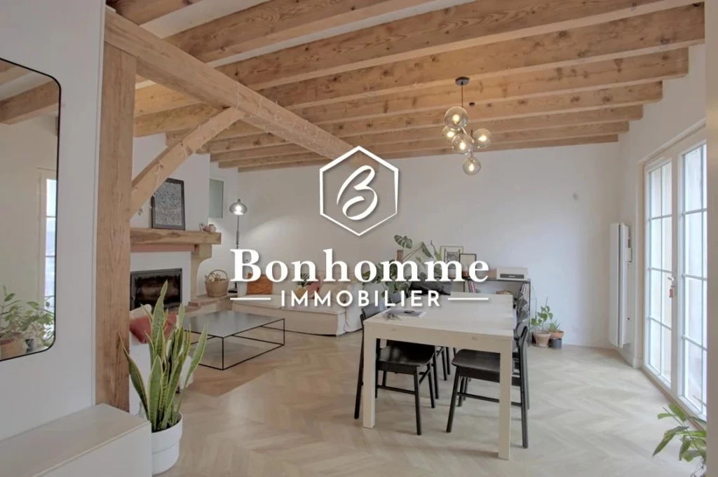 Charmant intérieur lumineux avec poutres en bois apparentes et espace convivial.