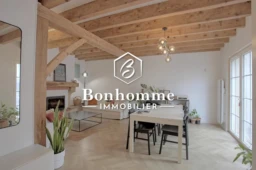 Charmant intérieur lumineux avec poutres en bois apparentes et espace convivial.