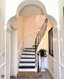 Une entrée remarquable qui donne le ton, mettant en valeur un superbe escalier en fer forgé suspendu et des lignes architecturales élégantes