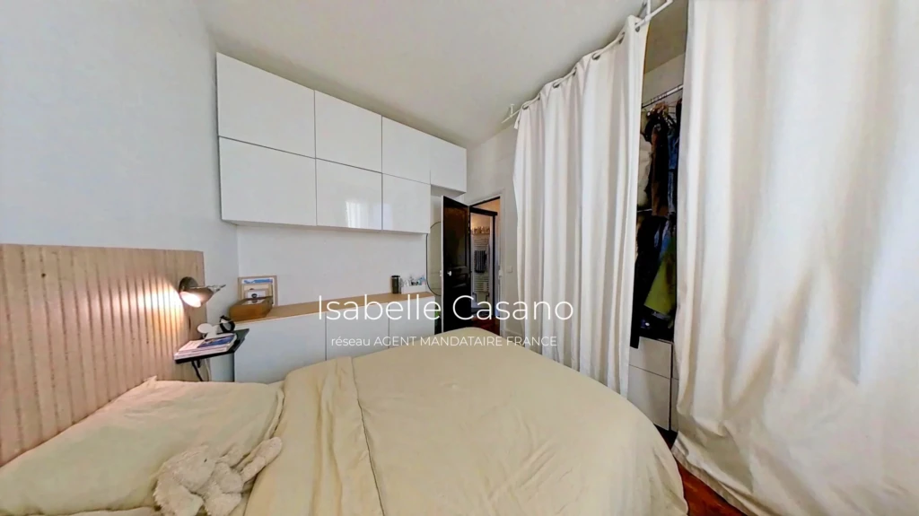 Chambre lumineuse avec rangement intégré et décoration épurée.