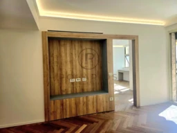 Cette image montre une pièce moderne avec un mur en bois, un plancher en bois à chevrons, et un plafond lumineux.