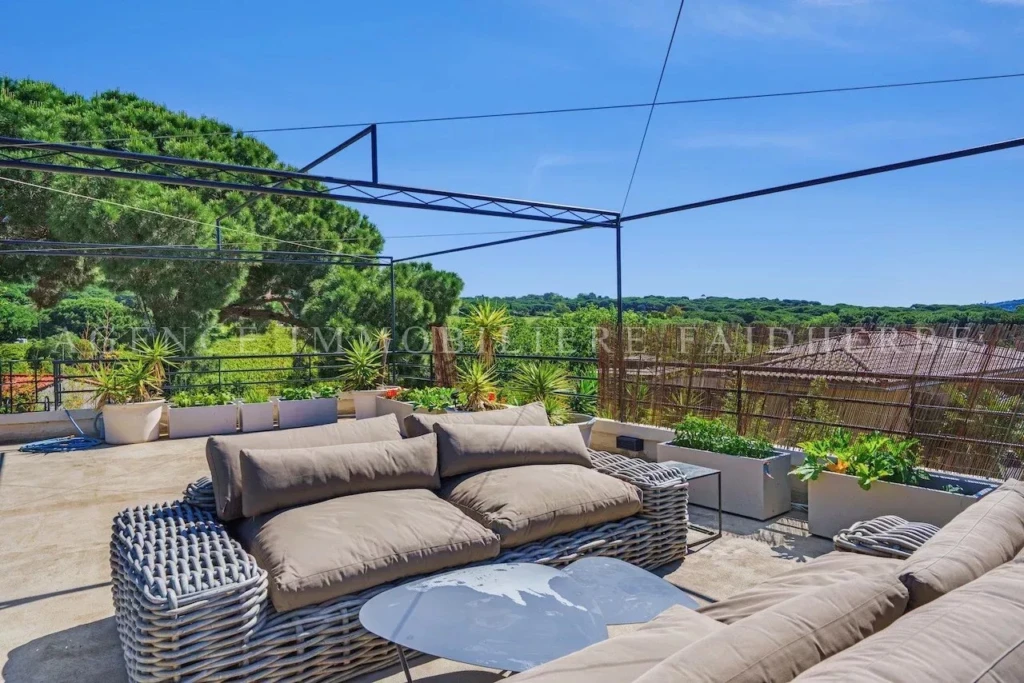 Terrasse ensoleillée avec vue panoramique et mobilier confortable.