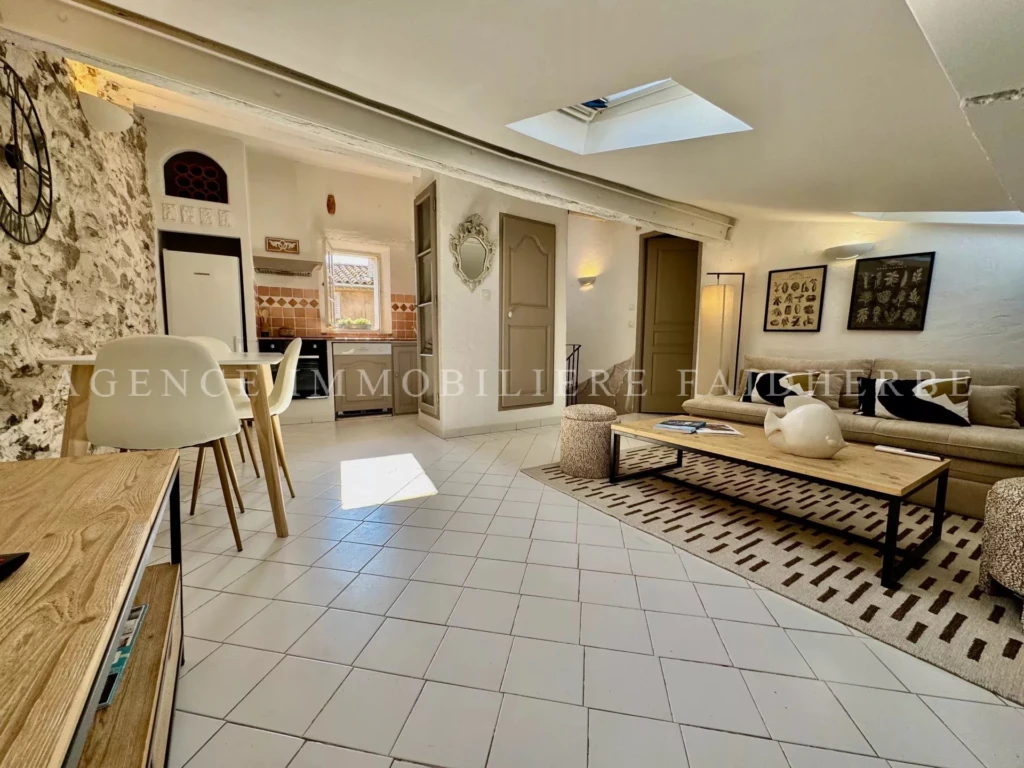 Salon spacieux et lumineux avec toit en pente et décoration moderne.