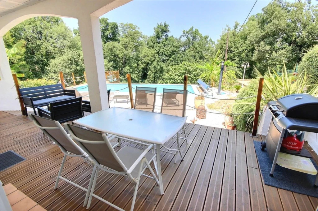 Terrasse en bois avec mobilier extérieur et piscine privée, idéale pour profiter du plein air.