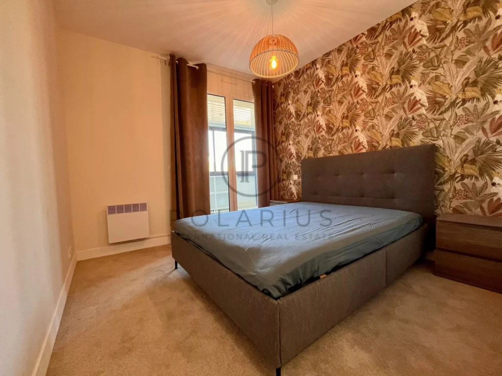 Chambre lumineuse avec une décoration moderne et un mur à motif floral.