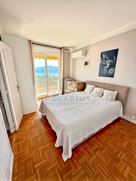 Chambre lumineuse avec vue sur l'extérieur, espace confortable et décoration simple.