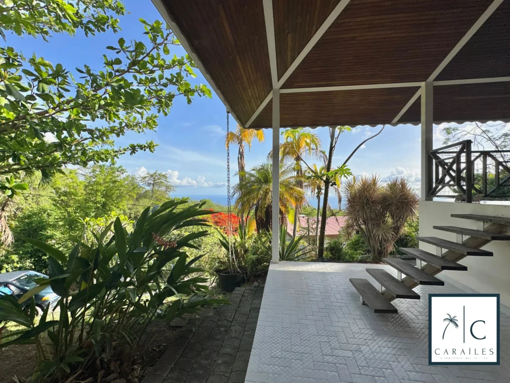Terrasse spacieuse avec vue sur la nature et la mer en arrière-plan.