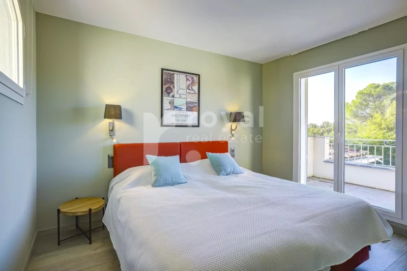 Chambre spacieuse d'une villa de luxe au Royal Mougins Golf, avec literie haut de gamme et vue sur le jardin