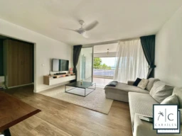 Salon lumineux avec balcon offrant une vue dégagée.
