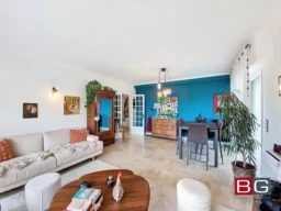 Salon lumineux avec décoration moderne et accès à un balcon.