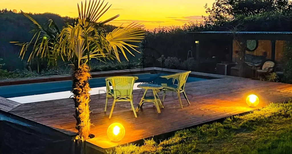 Une terrasse en bois avec mobilier coloré au coucher du soleil, idéale pour la détente.