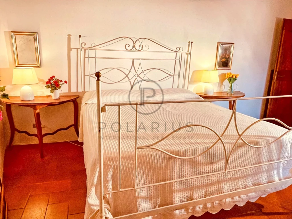 Chambre confortable avec lit en fer forgé et lampes d'appoint chaudes.