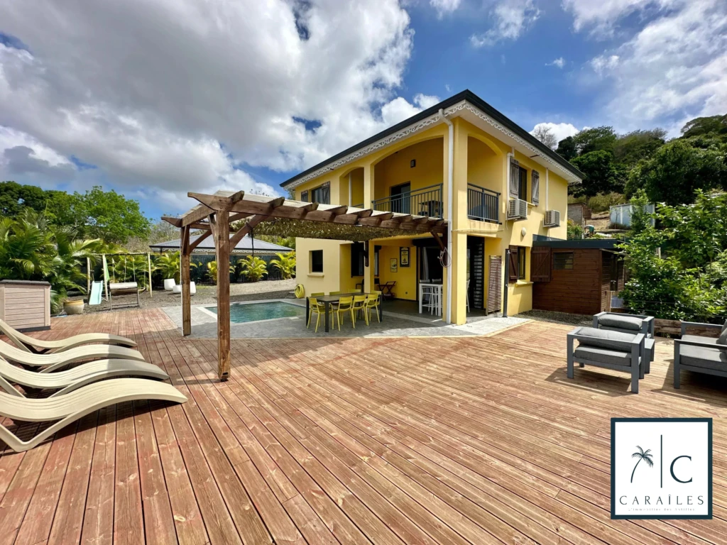 Maison spacieuse avec une grande terrasse et une piscine, idéale pour la détente et les loisirs.