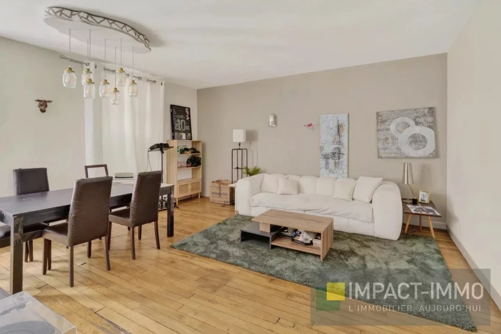 Salon lumineux avec canapé blanc et décor moderne.