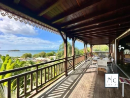 Terrasse en bois avec vue panoramique sur la mer et la nature environnante.