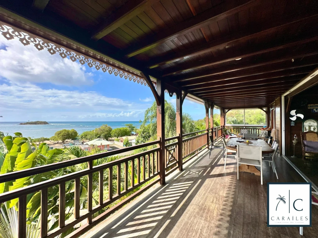 Terrasse en bois avec vue panoramique sur la mer et la nature environnante.