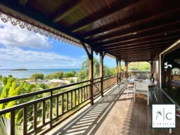 Terrasse en bois avec vue panoramique sur la mer et la nature environnante.