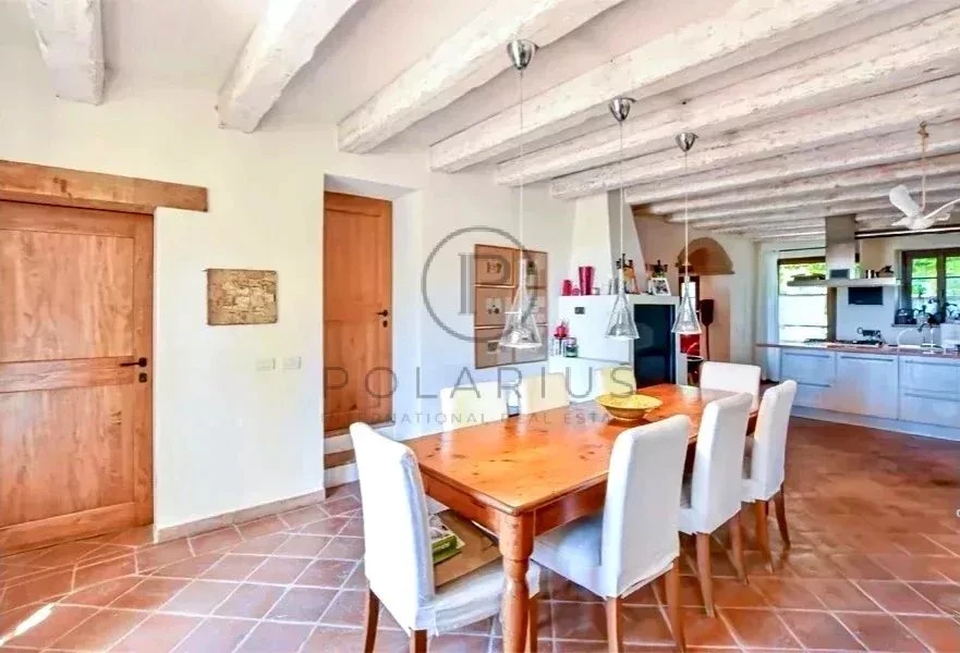 Salle à manger lumineuse avec un plafond en bois et une cuisine moderne en arrière-plan.