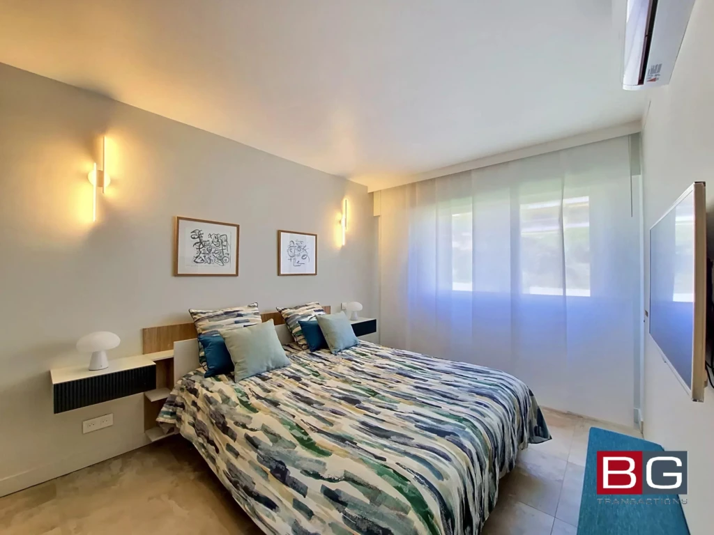 Chambre lumineuse avec décoration moderne et grande fenêtre offrant une vue agréable.