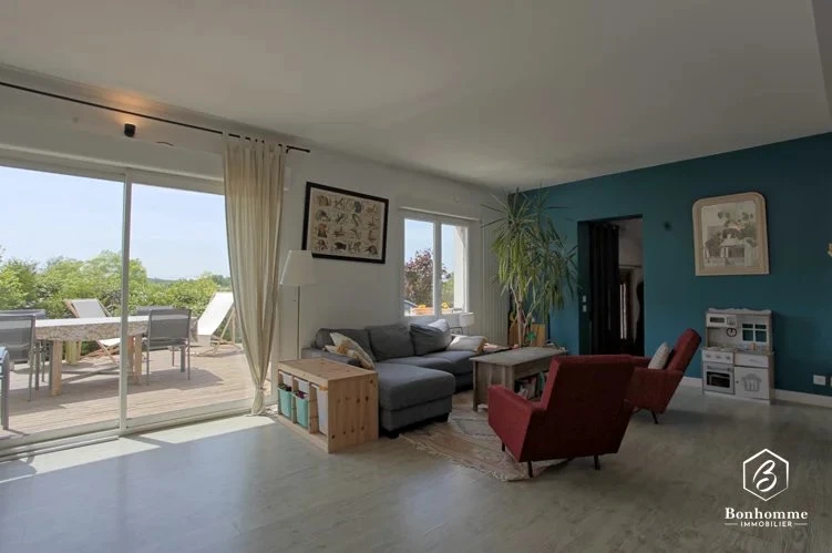 Salon lumineux avec accès à une terrasse extérieure.