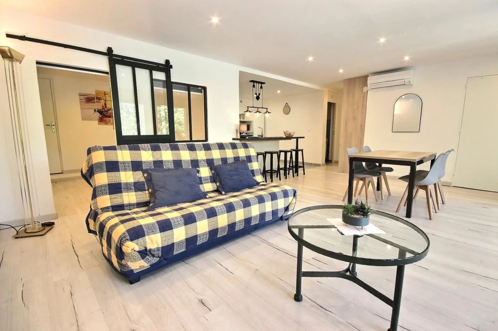 Salon lumineux avec un canapé à carreaux et un mobilier moderne - Les Adrets-de-l'Estérel