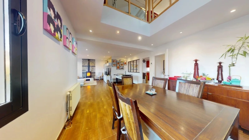 Une salle à manger moderne avec des murs décorés, un grand tableau en bois et un éclairage chaleureux.