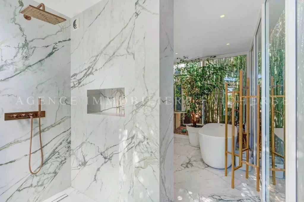 Salle de bain moderne avec baignoire autoportante et vue sur le jardin.