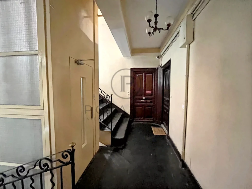 Entrée charmante avec un escalier en colimaçon et un plafond orné d'un lustre élégant.
