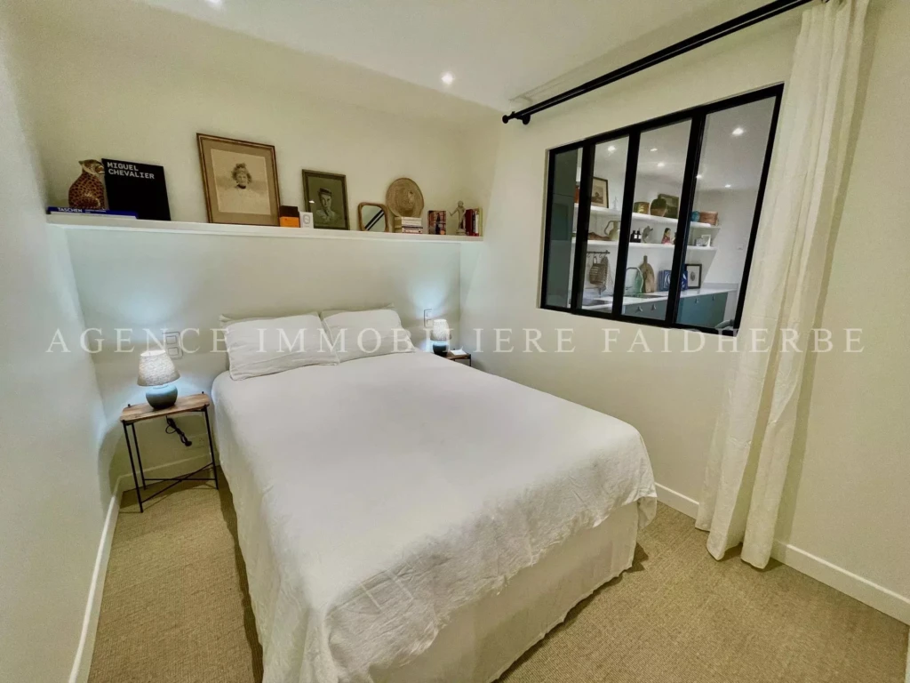 Chambre lumineuse avec un lit confortable et une décoration élégante.
