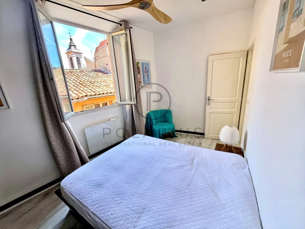 Chambre lumineuse avec vue sur le clocher de l'église dans un quartier charmant.