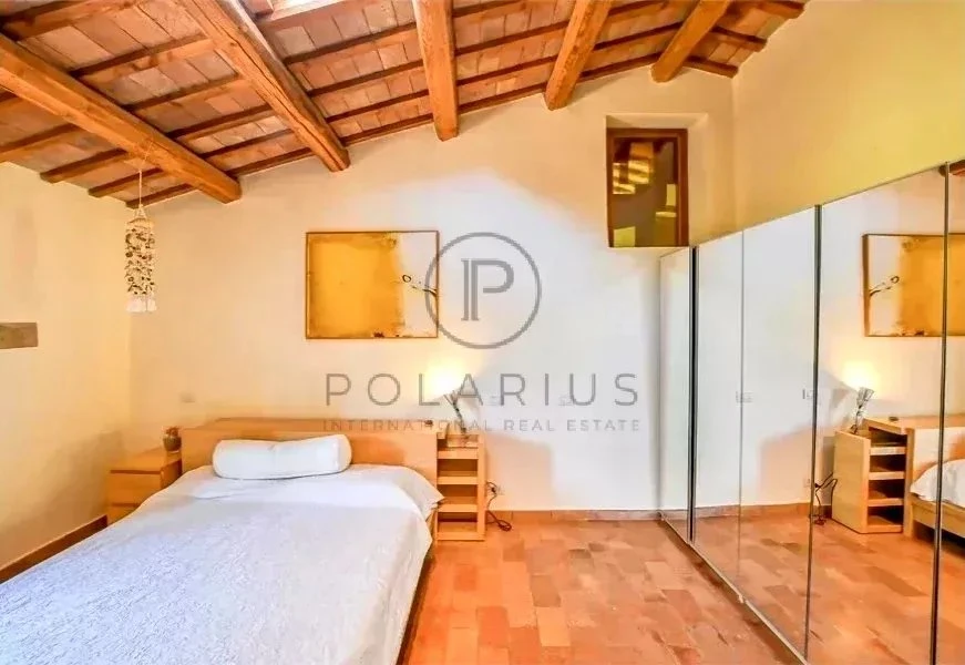 Chambre lumineuse avec un élégant plafond en bois et un grand miroir dans cette propriété à vendre.