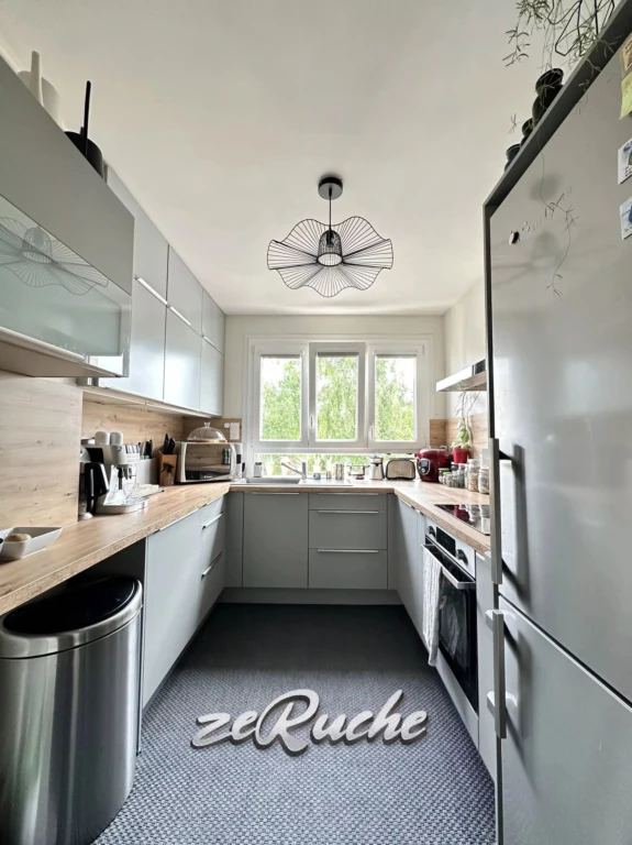 Cuisine lumineuse et moderne avec un grand espace de rangement.