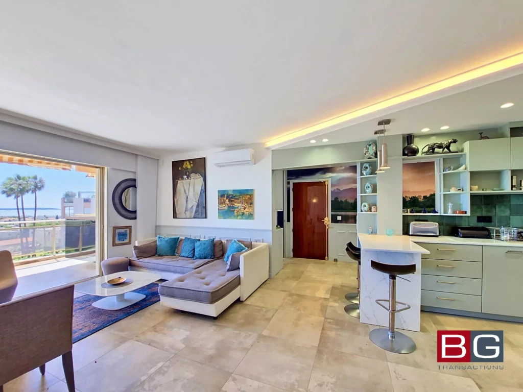 Un salon lumineux avec vue sur la mer et une cuisine moderne dans cet appartement spacieux.