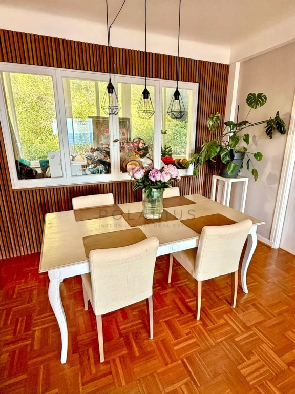 Salle à manger lumineuse avec vue sur le jardin et mobilier élégant.