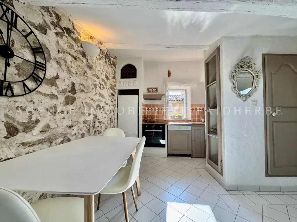 Charmante cuisine lumineuse dans une maison de caractère avec murs en pierre et éléments modernes.