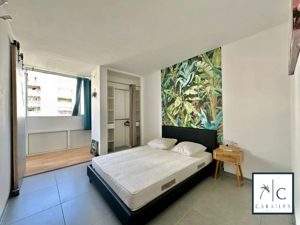 Chambre confortable avec une décoration moderne et une belle murale végétale.