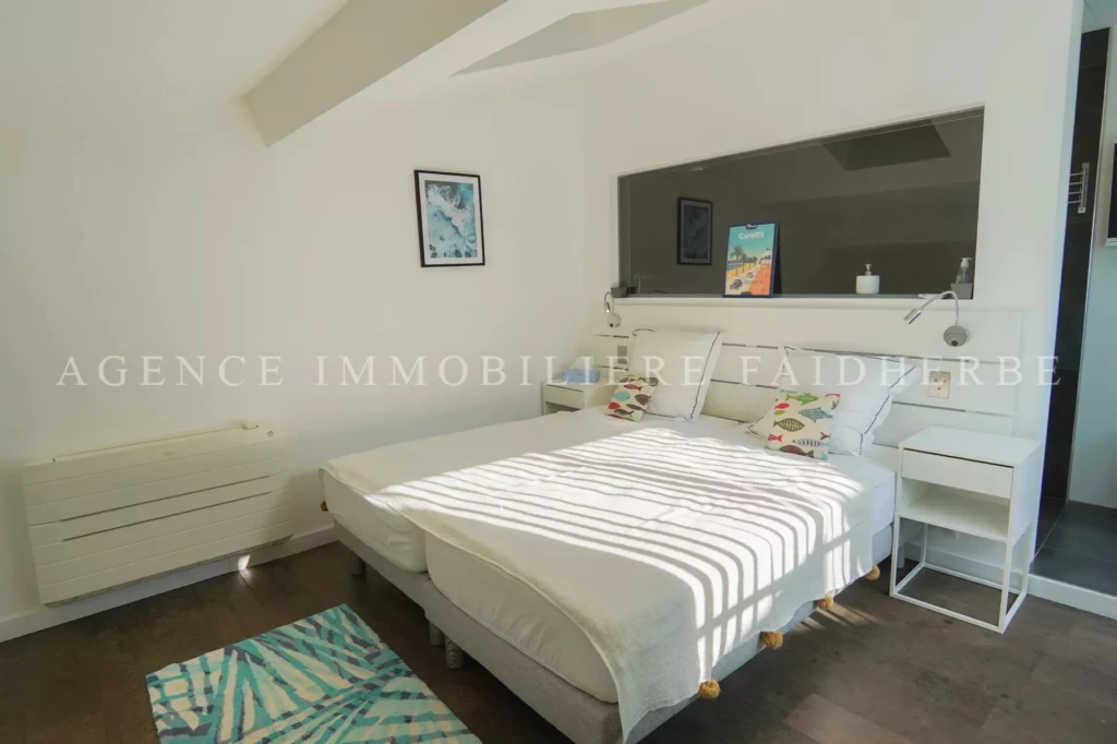 Chambre lumineuse avec lit double et décor moderne.