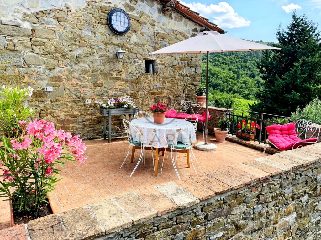 Terrasse ensoleillée avec vue sur la campagne et mobilier charmant.