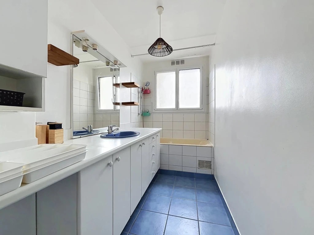 Cuisine lumineuse avec espace fonctionnel et fenêtre offrant une lumière naturelle.