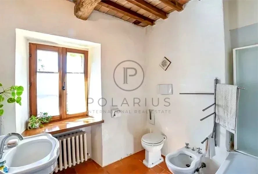 Belle salle de bain lumineuse avec fenêtre en bois et décoration simple.