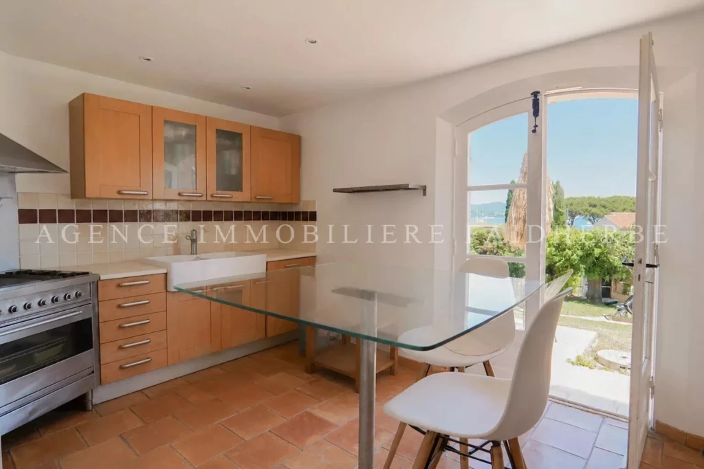 Cuisine lumineuse avec vue sur le jardin et accès à la terrasse.