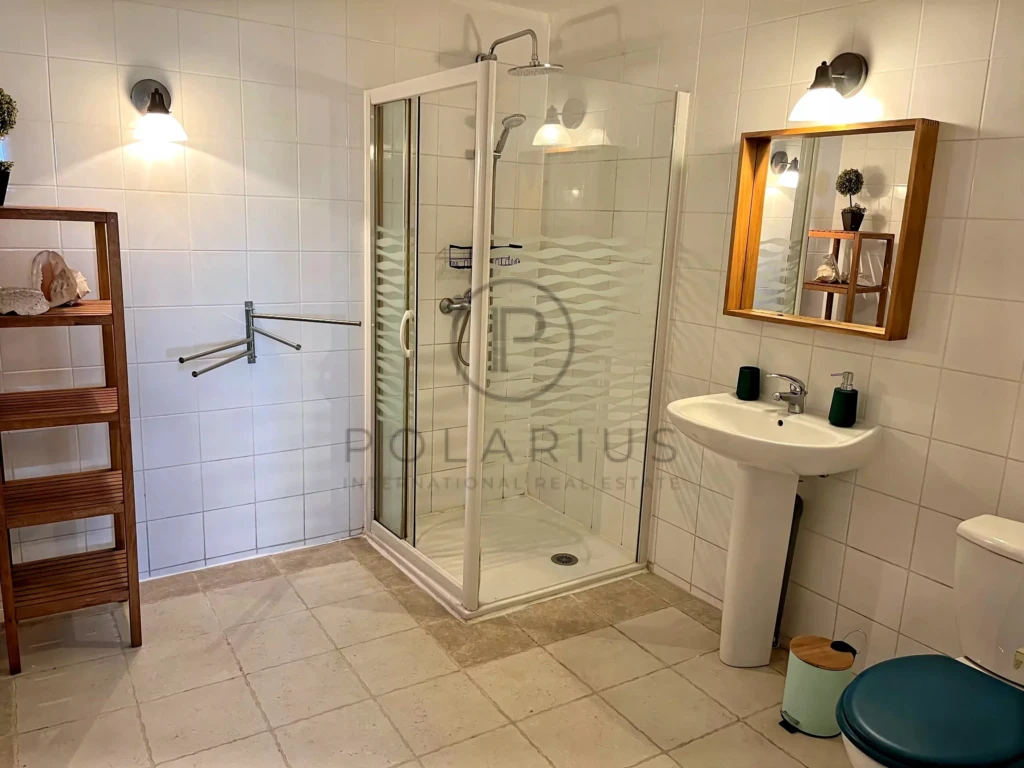 Salle de bain moderne avec douche, lavabo et toilettes dans une décoration épurée.
