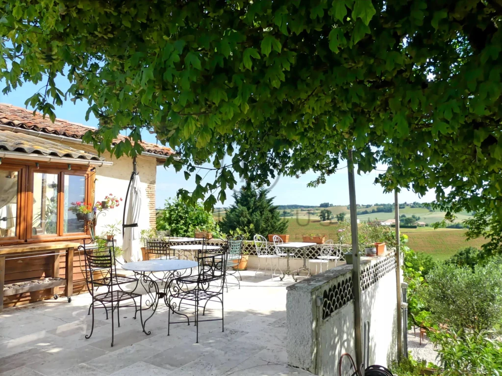 Terrasse ensoleillée avec vue panoramique sur la campagne.