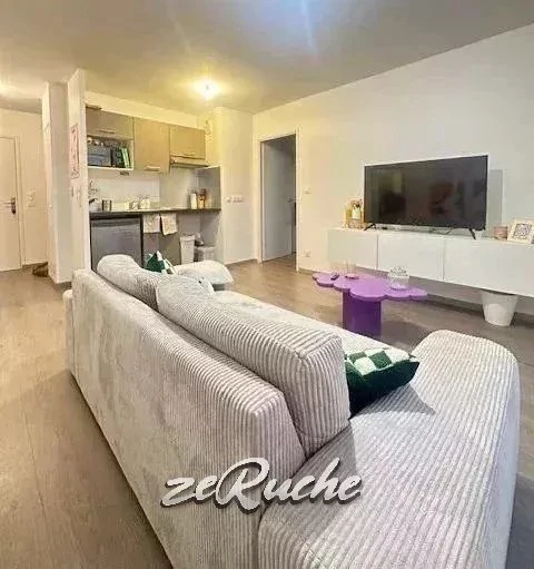 Salon lumineux avec un mobilier moderne et une télévision à écran plat.