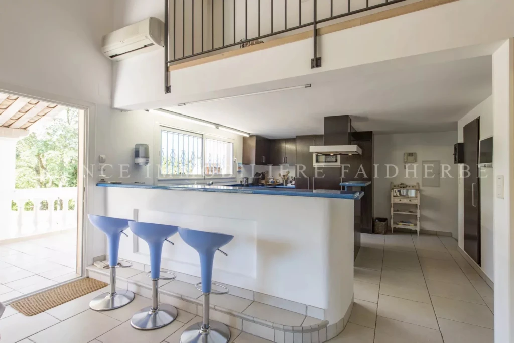 Cuisine moderne lumineuse avec un espace de repas et un coin salon convivial.