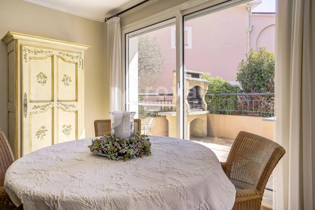 Salle à manger avec accès sur une terrasse d'angle avec barbecue dans une villa de standing sur le Royal Mougins golf