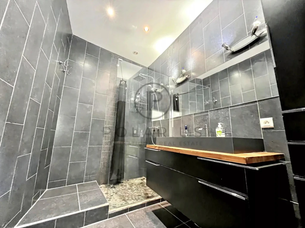 Salle de bain moderne avec douche à l'italienne et double lavabo, idéale pour votre confort.