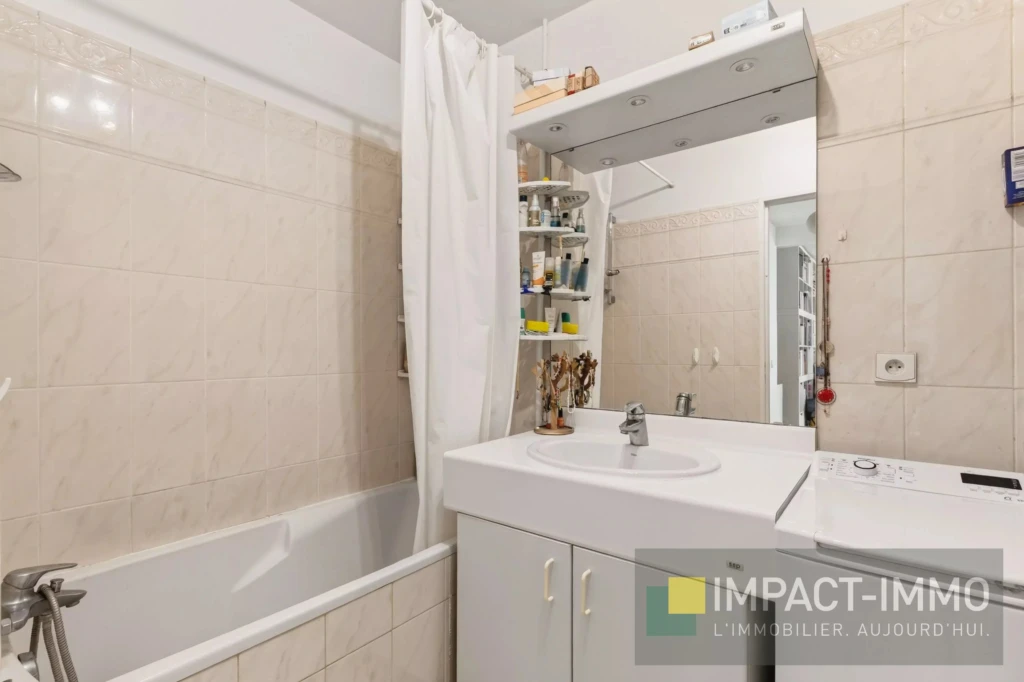 Salle de bain moderne avec baignoire, lavabo et espace de rangement pratique.