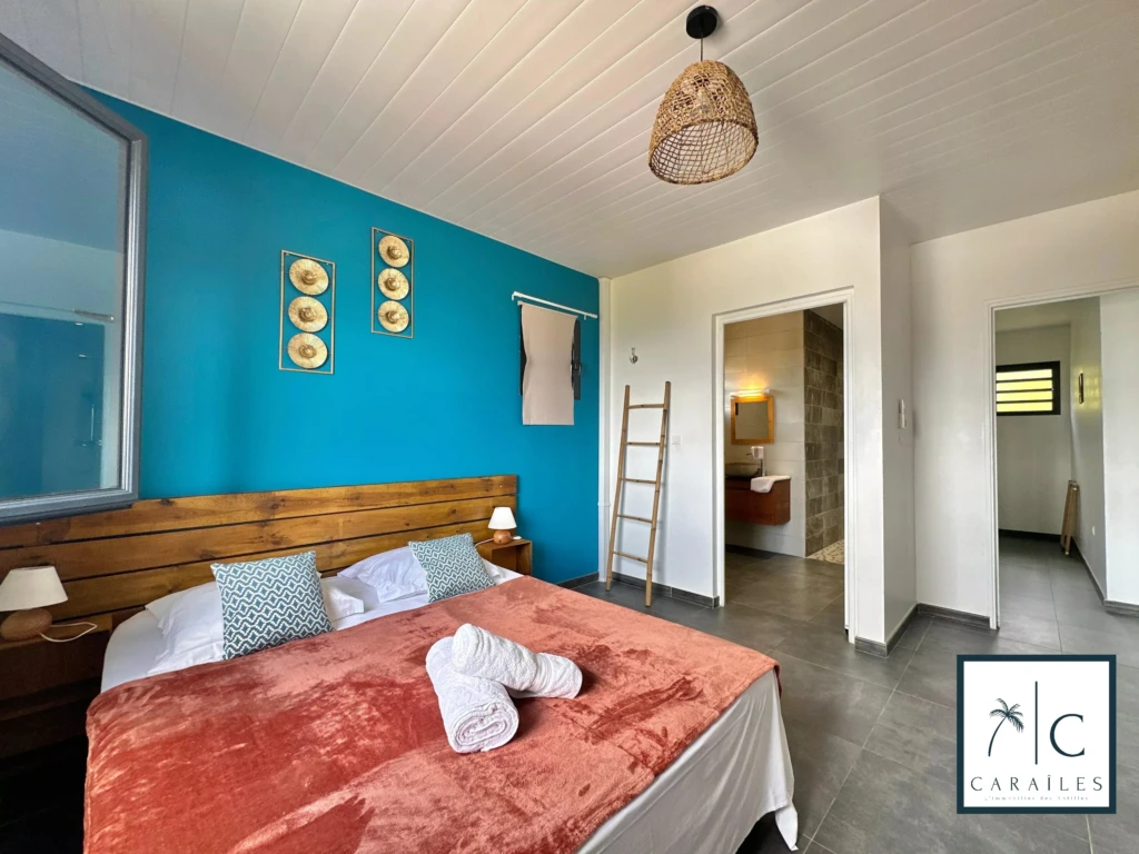 Chambre lumineuse avec un mur bleu et une décoration moderne.