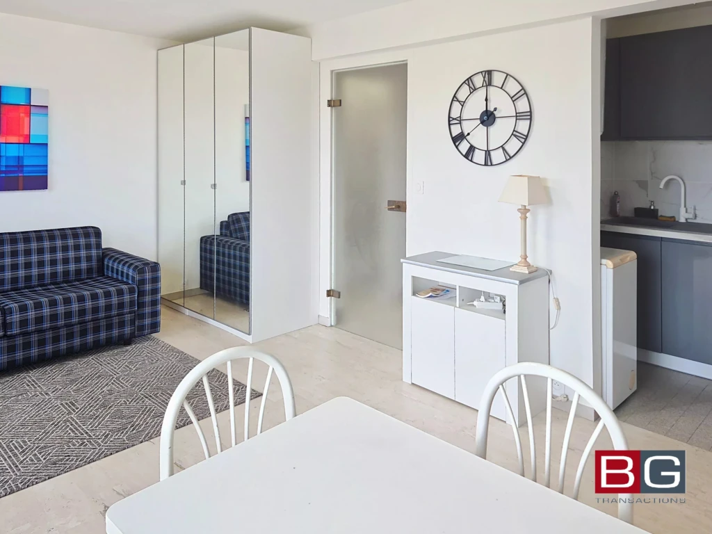 Appartement lumineux avec salon moderne, salle à manger et cuisine équipée.